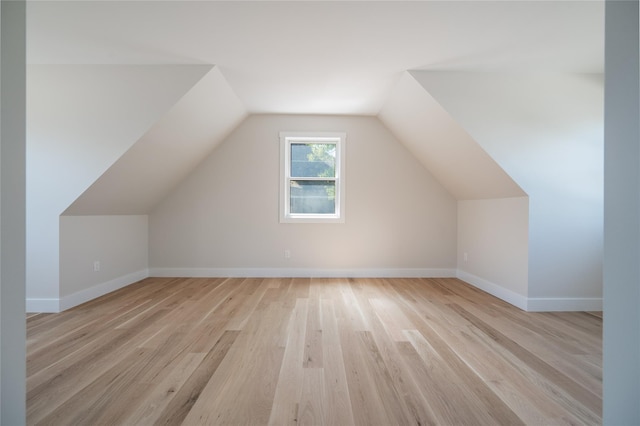 additional living space with lofted ceiling and light hardwood / wood-style floors