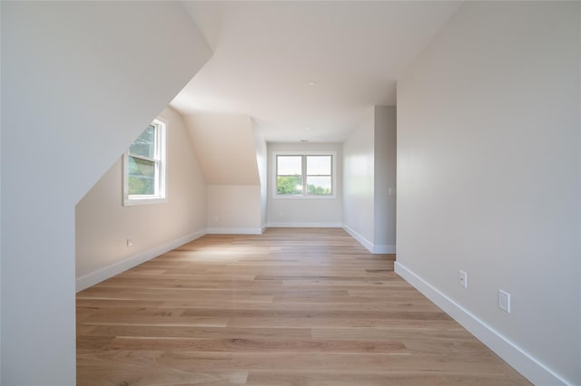 bonus room with lofted ceiling and light hardwood / wood-style floors