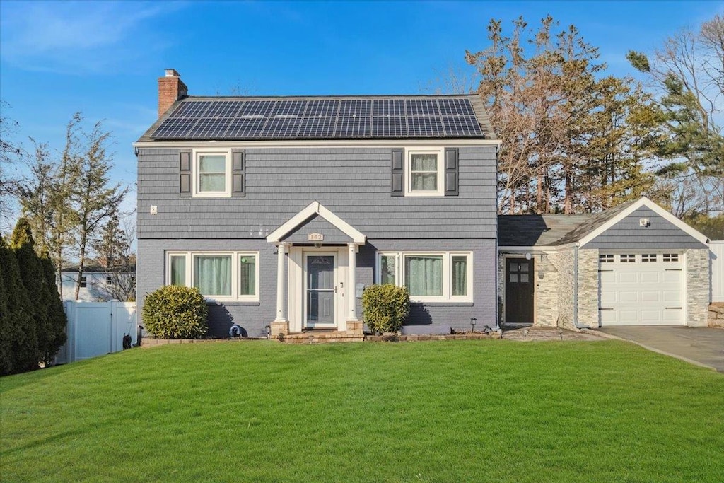 view of front facade with a front lawn and solar panels