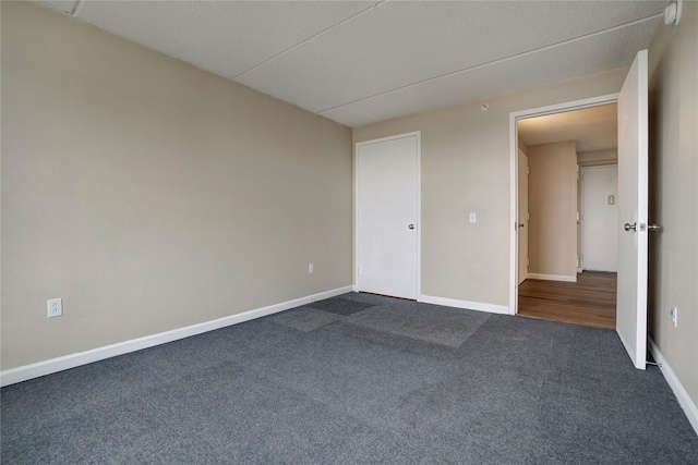 unfurnished bedroom with dark carpet