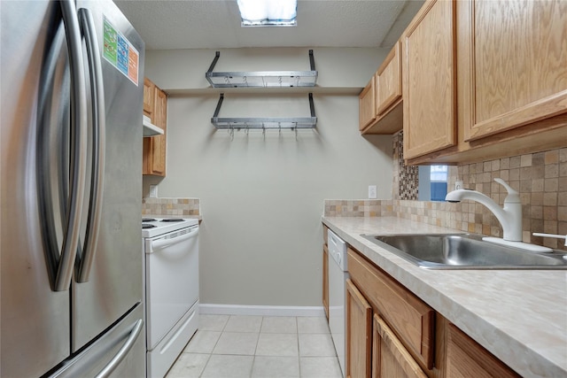 kitchen with tasteful backsplash, sink, light tile patterned floors, white appliances, and a textured ceiling