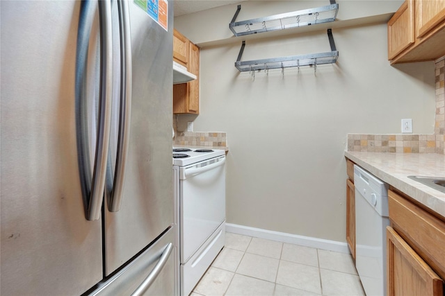 kitchen with light tile patterned flooring, white appliances, and decorative backsplash