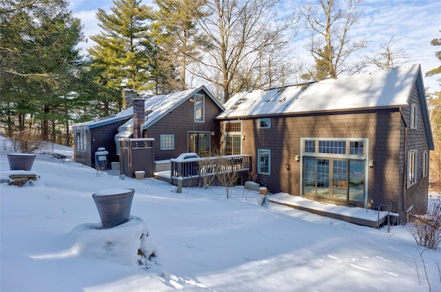 snow covered house featuring a deck