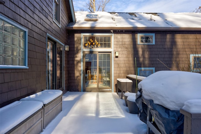 snow covered patio with french doors and area for grilling