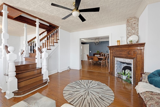 living room with an ornate ceiling, stairway, hardwood / wood-style floors, a premium fireplace, and baseboards