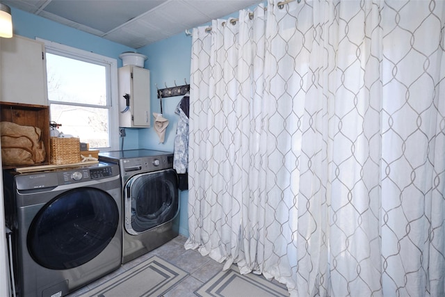 clothes washing area with washer and dryer, electric panel, cabinet space, and tile patterned floors