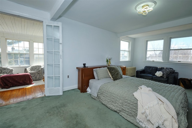 bedroom with beamed ceiling, carpet, and baseboards