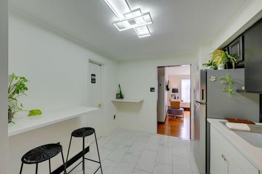 kitchen with a breakfast bar, freestanding refrigerator, white cabinets, and light countertops