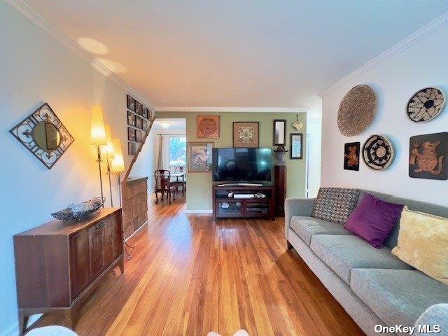 living room featuring crown molding and hardwood / wood-style flooring