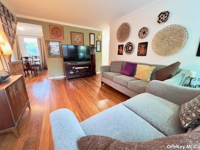 living room with crown molding and hardwood / wood-style flooring