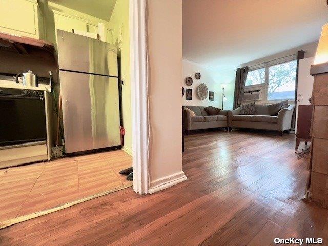 kitchen with stainless steel refrigerator, wood-type flooring, and range