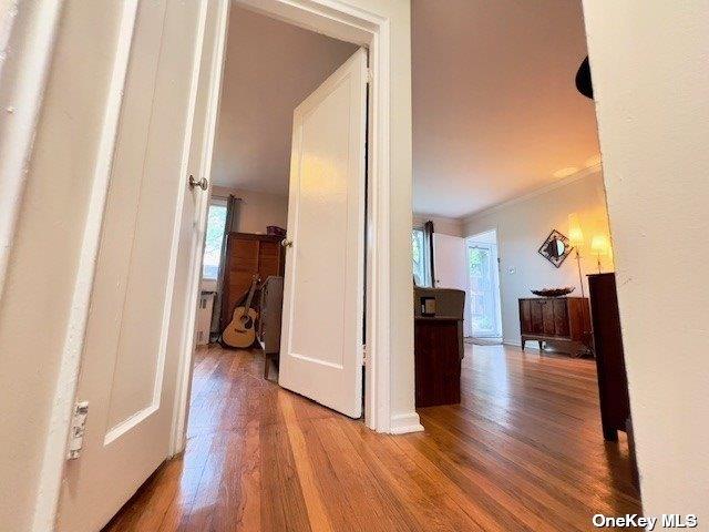 hall with hardwood / wood-style flooring and ornamental molding