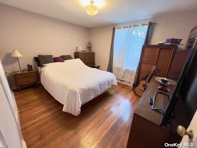 bedroom with dark hardwood / wood-style flooring