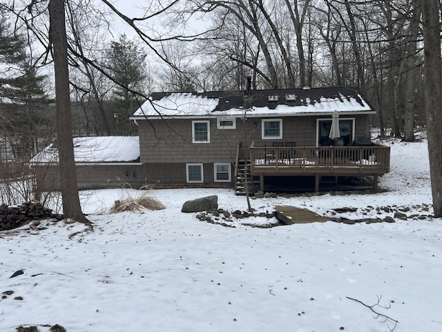 snow covered house featuring a wooden deck