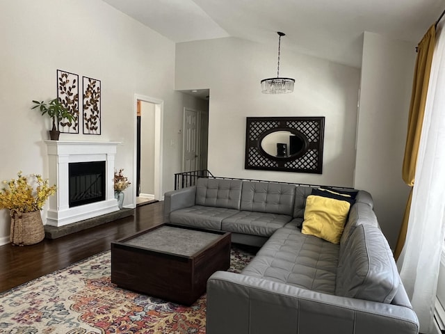 living room featuring hardwood / wood-style floors, vaulted ceiling, and a baseboard radiator