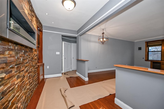 entrance foyer with ornamental molding, hardwood / wood-style floors, and a notable chandelier