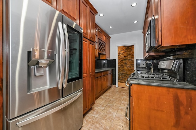 kitchen featuring stainless steel appliances, tasteful backsplash, and dark stone countertops