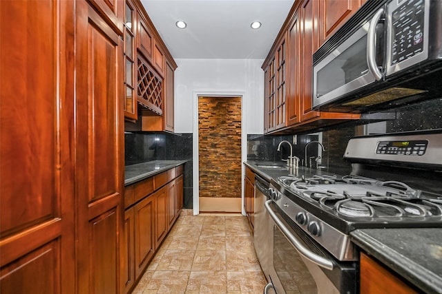 kitchen with appliances with stainless steel finishes, decorative backsplash, and dark stone countertops