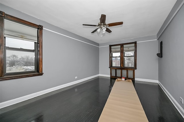 empty room with dark hardwood / wood-style flooring and ceiling fan