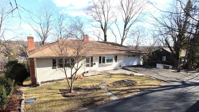 ranch-style home with a garage and a front lawn