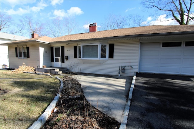 single story home with a garage and a front lawn