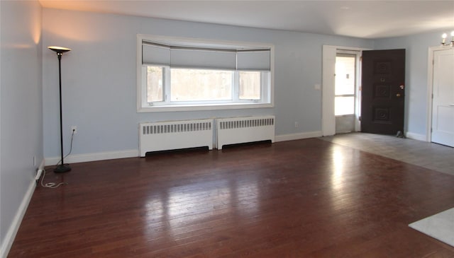 foyer featuring an inviting chandelier, dark hardwood / wood-style floors, and radiator