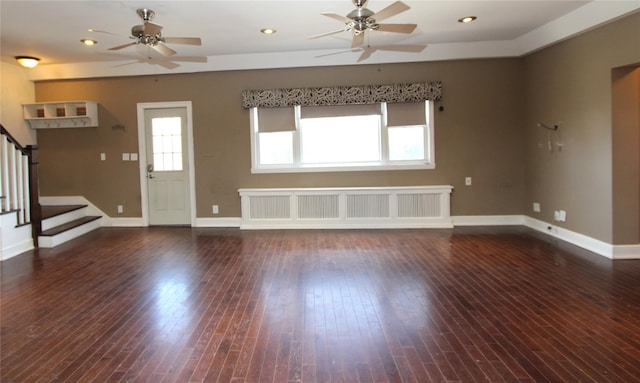 unfurnished living room with dark wood-type flooring, radiator heating unit, and ceiling fan