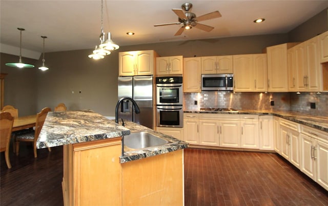 kitchen featuring sink, hanging light fixtures, stainless steel appliances, a center island, and tasteful backsplash