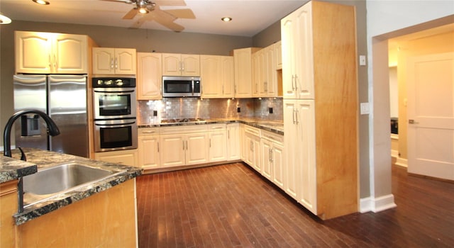 kitchen with stainless steel appliances, tasteful backsplash, sink, and dark hardwood / wood-style floors