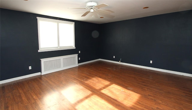 empty room featuring wood-type flooring, radiator heating unit, and ceiling fan