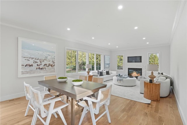 dining area featuring crown molding and light hardwood / wood-style flooring