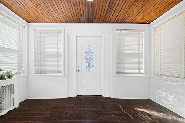 foyer with dark wood-type flooring, wooden ceiling, and plenty of natural light