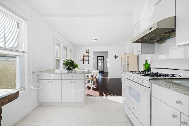 kitchen with white cabinetry and white gas stove