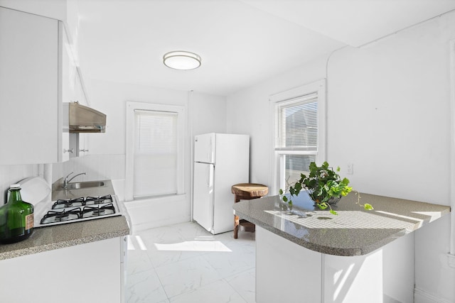 kitchen with sink, white cabinetry, stove, range hood, and white refrigerator