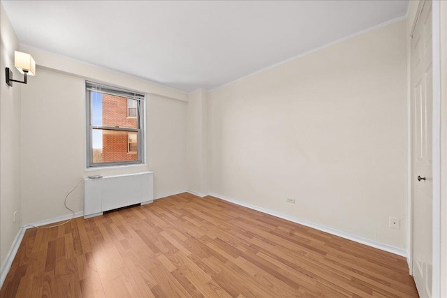 spare room with radiator and light hardwood / wood-style flooring