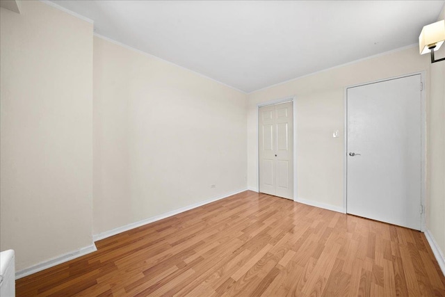 unfurnished bedroom with crown molding and light hardwood / wood-style floors