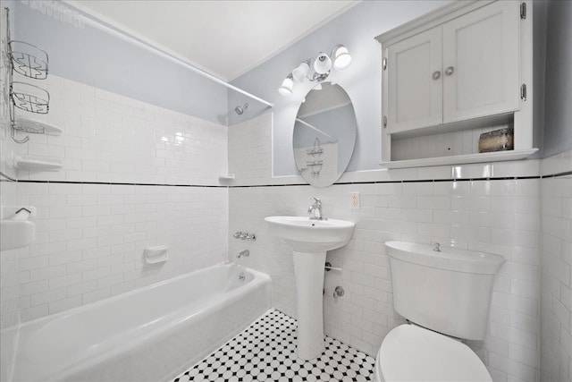 bathroom with tiled shower / bath, tile walls, tile patterned floors, and toilet