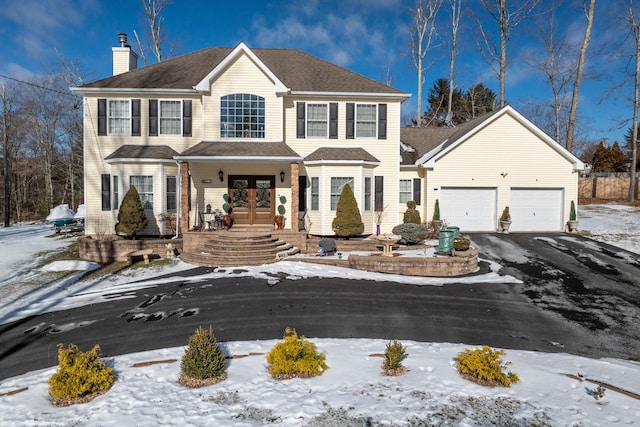 colonial-style house featuring a garage and french doors