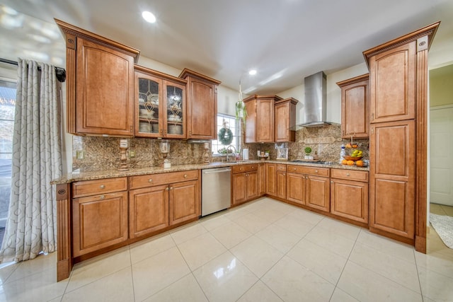 kitchen featuring appliances with stainless steel finishes, sink, backsplash, light stone countertops, and wall chimney exhaust hood