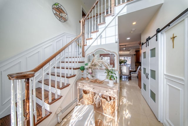 stairs featuring a barn door and tile patterned floors