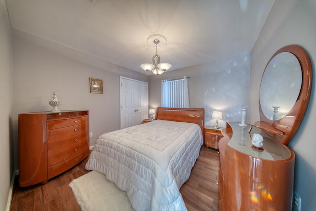 bedroom with hardwood / wood-style flooring, a closet, and a chandelier