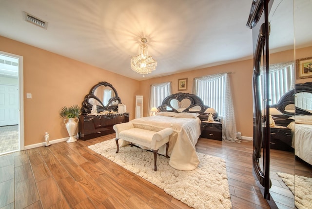 bedroom featuring hardwood / wood-style flooring and a notable chandelier