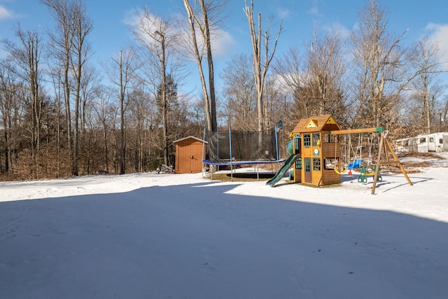 snow covered playground with a trampoline