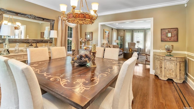 dining area with ornamental molding, wood-type flooring, and a notable chandelier