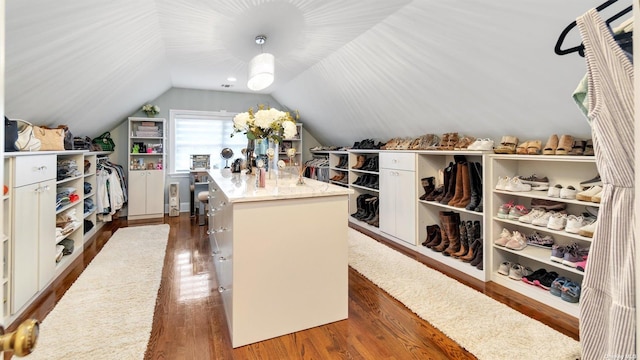 walk in closet with lofted ceiling and dark hardwood / wood-style flooring