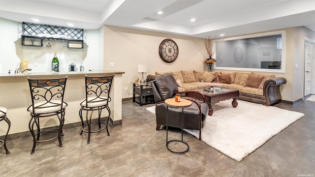 living room with bar area and a raised ceiling