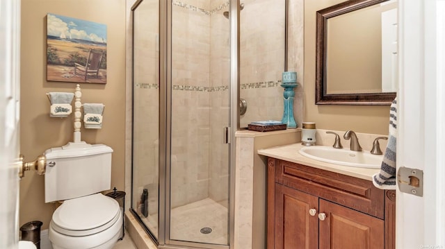 bathroom with vanity, toilet, and a shower with shower door