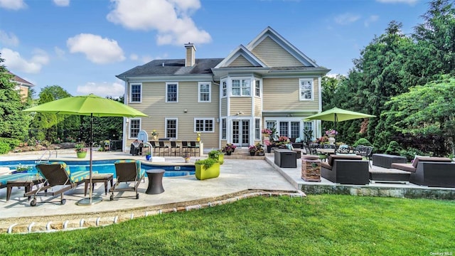 rear view of house featuring an outdoor living space, a yard, and a patio area