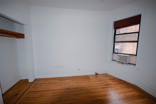 unfurnished room featuring cooling unit and wood-type flooring