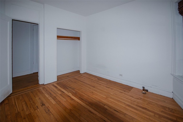 unfurnished bedroom featuring hardwood / wood-style floors and a closet